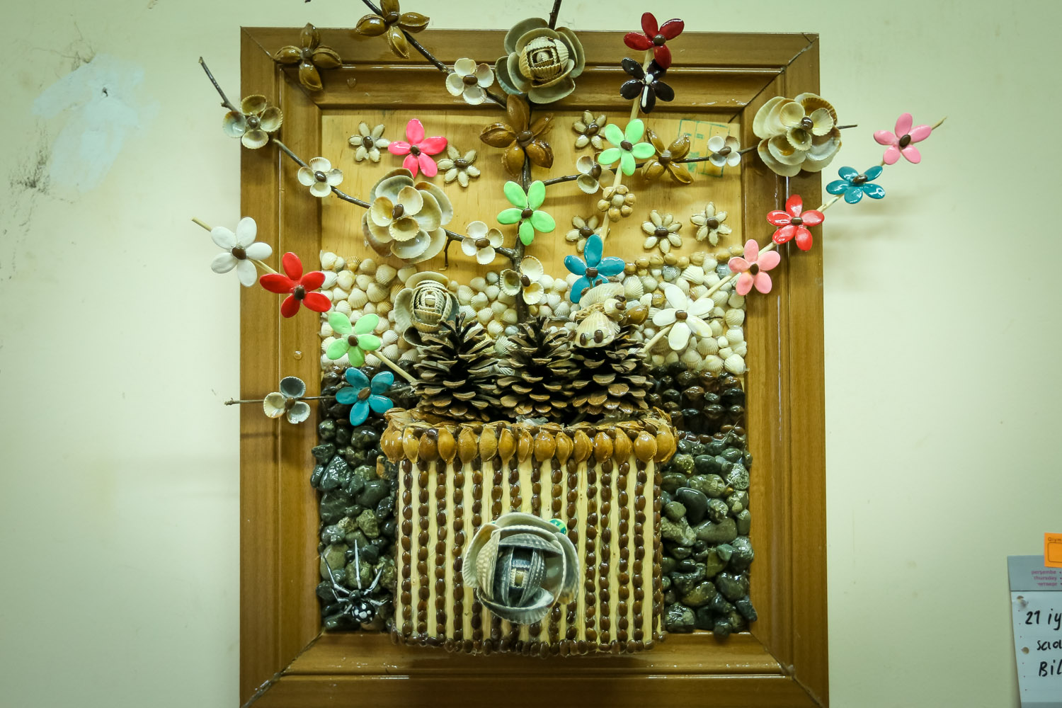 A flower portrait made out of shells, plum and peach seeds
