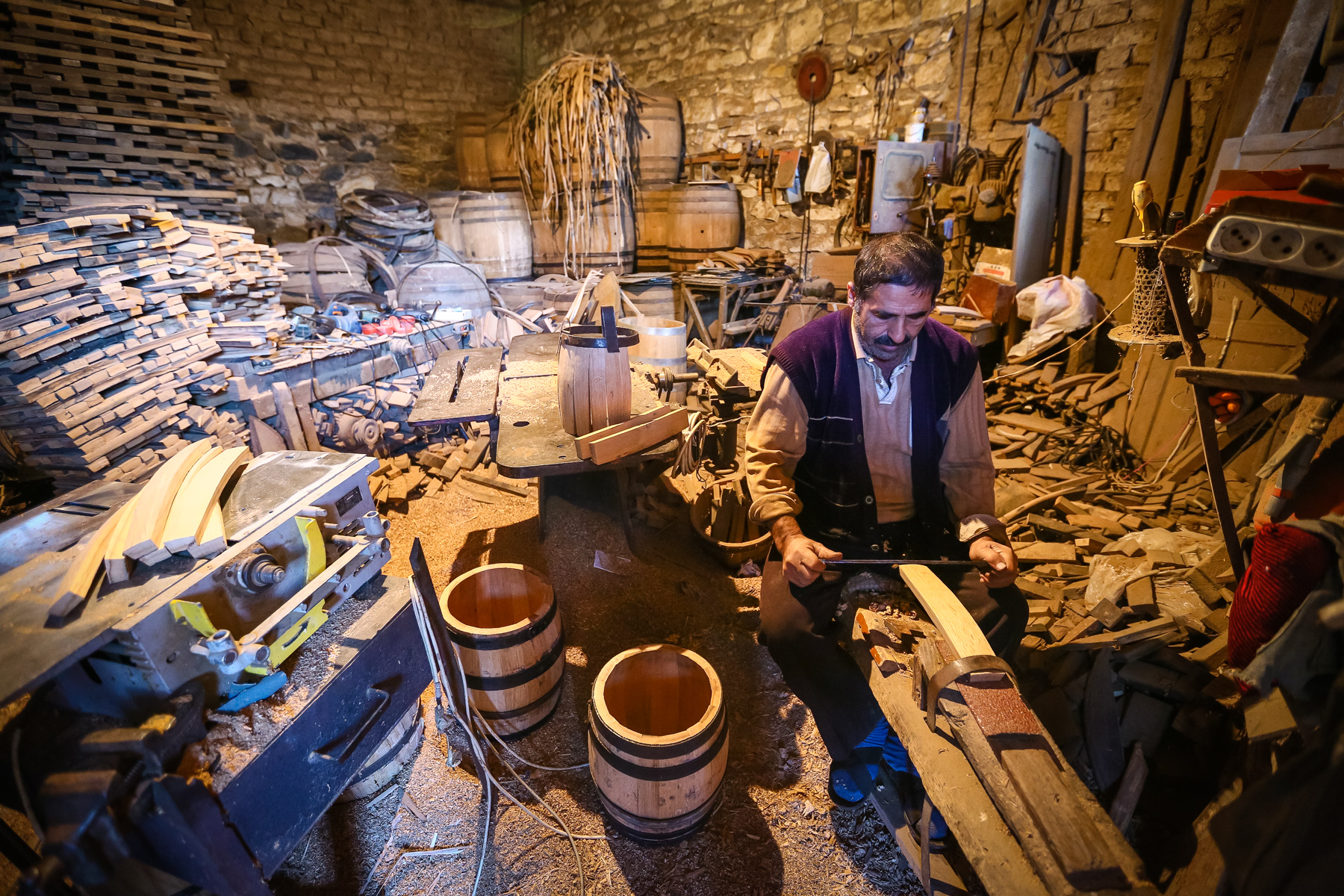 Cahan dayı yeni çəllək hazırlamaq üçün özünü hazırladığı alətdə taxtanı yonur