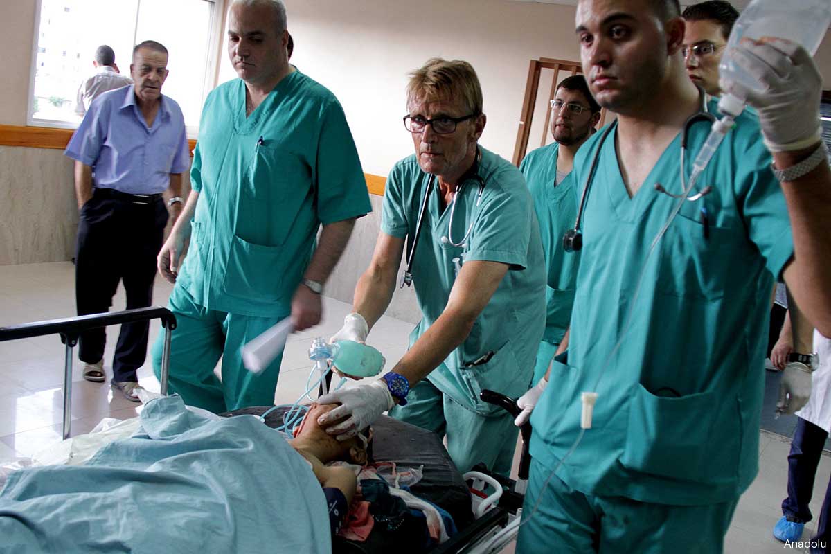 Dr. Mads Frederick Gilbert at Al-Shifa hospital on Jul.17, treating a wounded Palestinian child adter an Israeli air strike killed 4 children and wounded 5 others