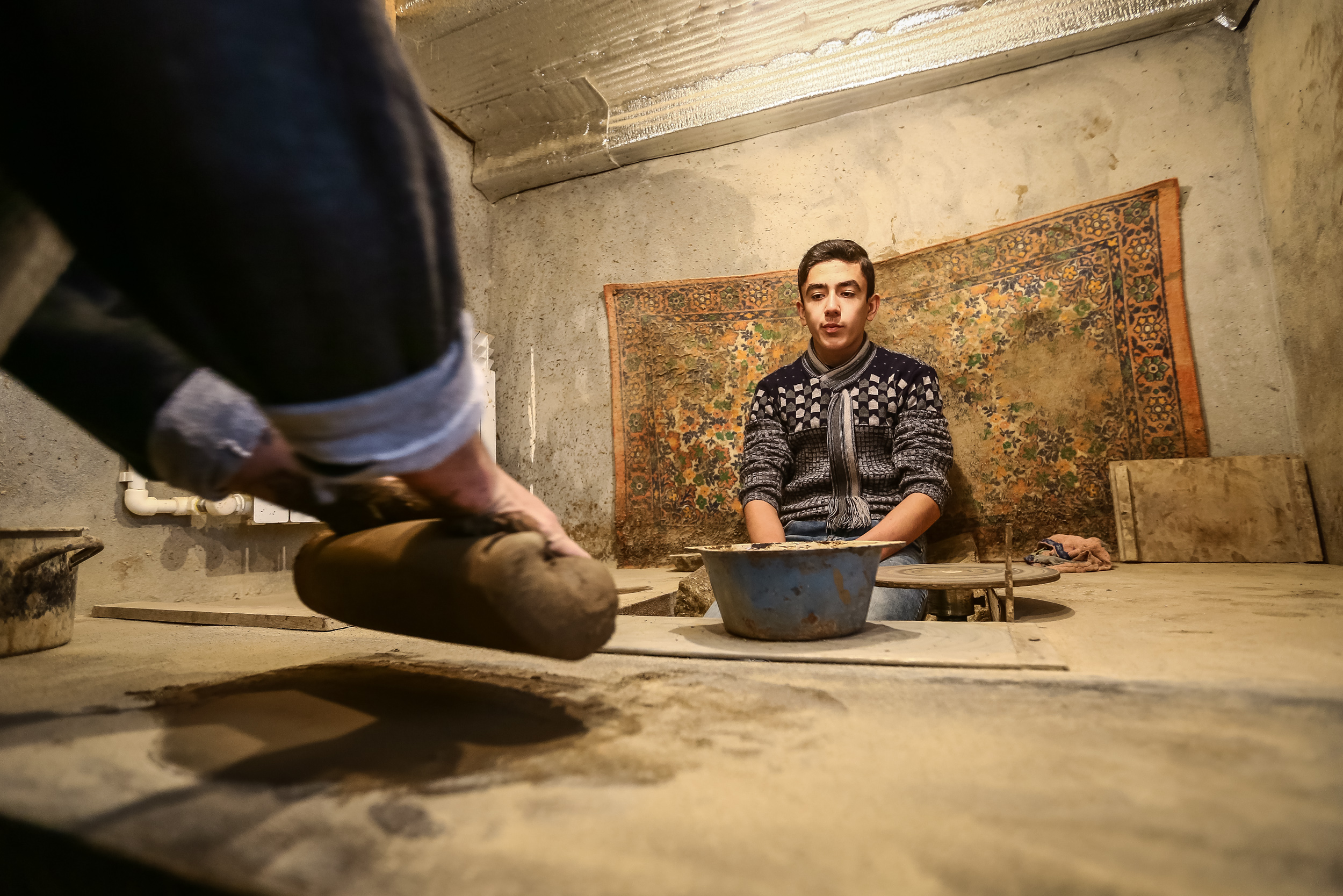 Əhəd usta pul qabı hazırlamaq üçün palçığı 5-10 dəqiqə əlləri ilə əzərək yumşaldır ki, işləmək daha rahat olsun