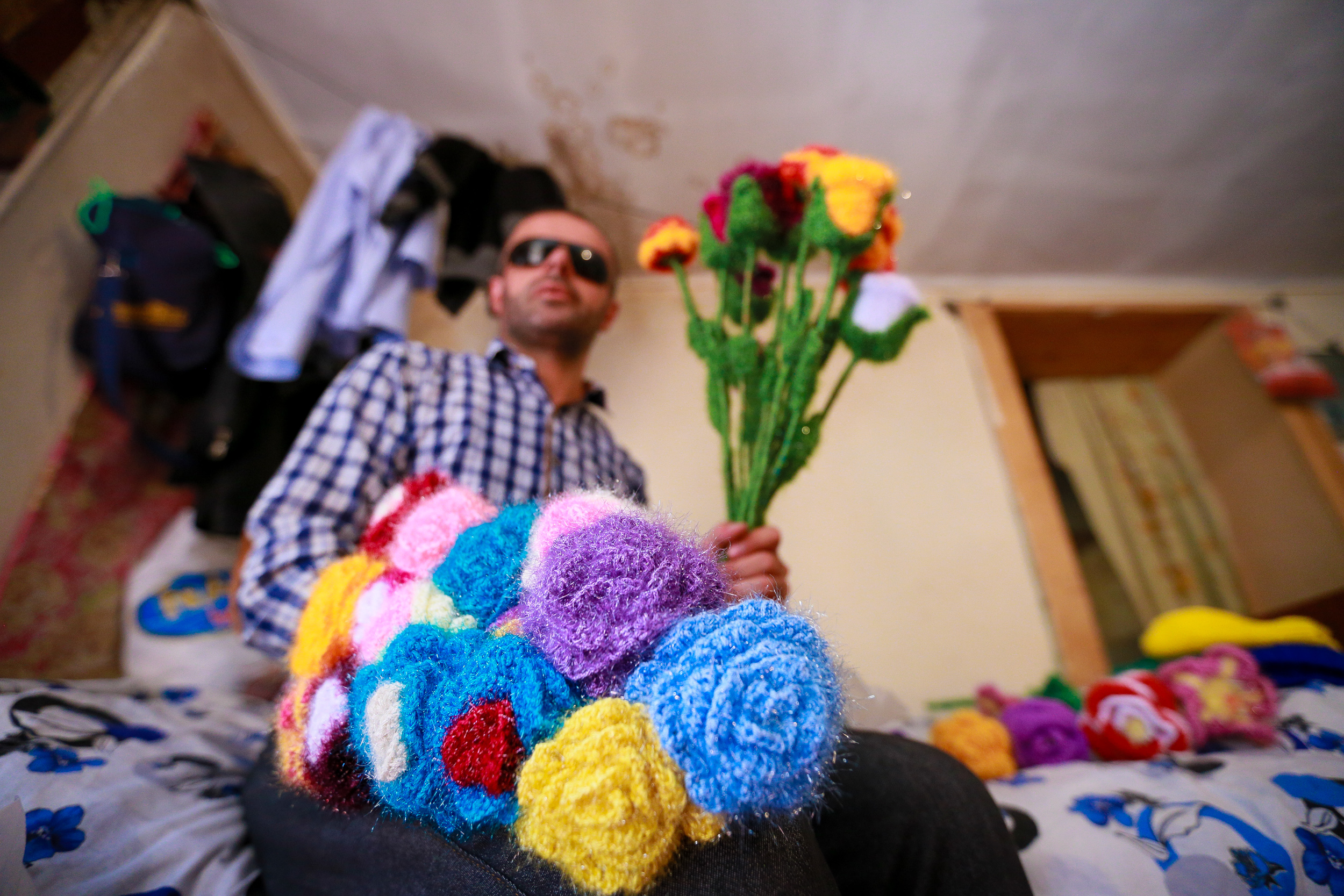 He knits flowers of different sizes and colors