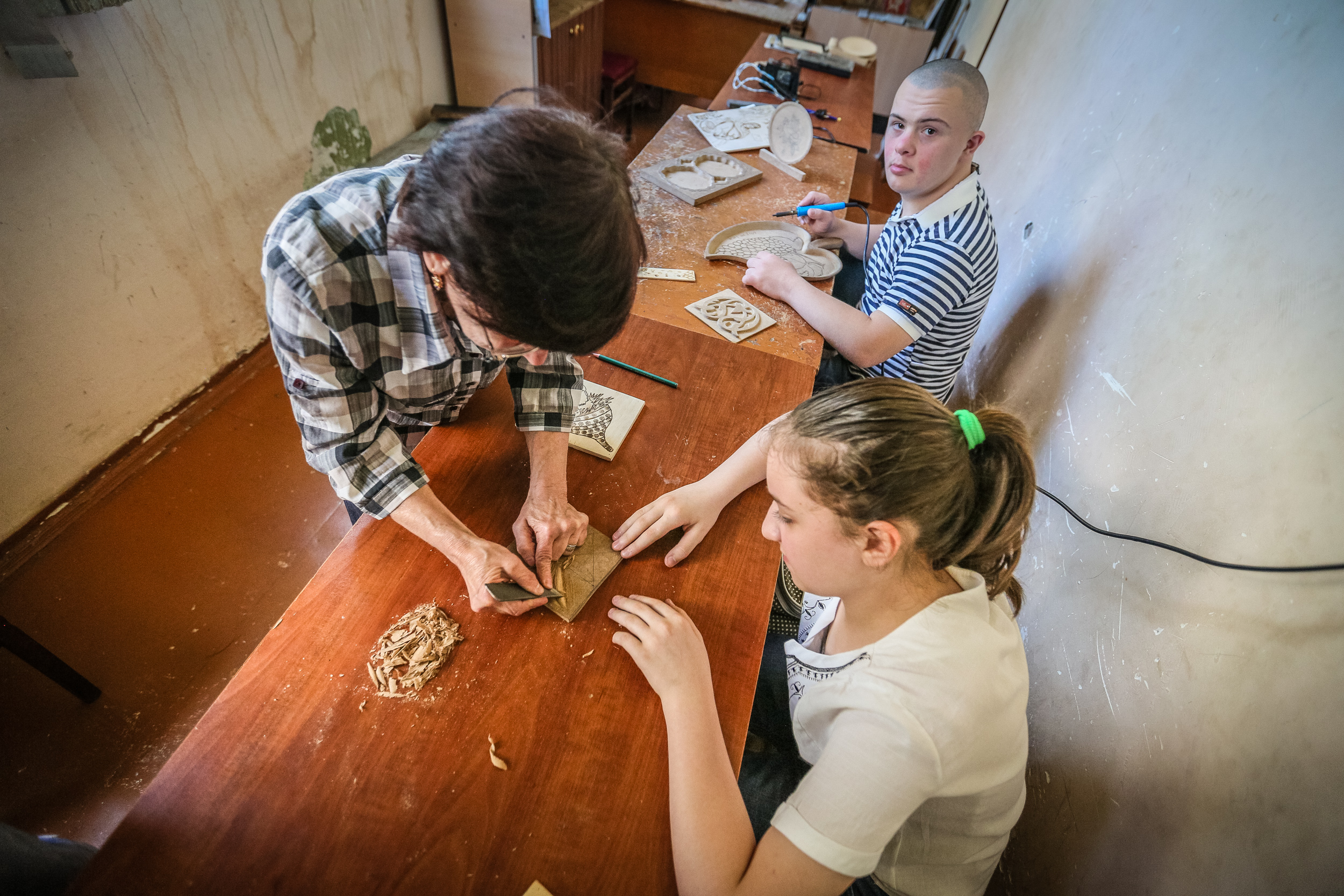 Kifayət xanım öz şagirdlərinə ağacın üzərində müxtəlif fiqurları necə işləmək lazım olduğunu göstərir