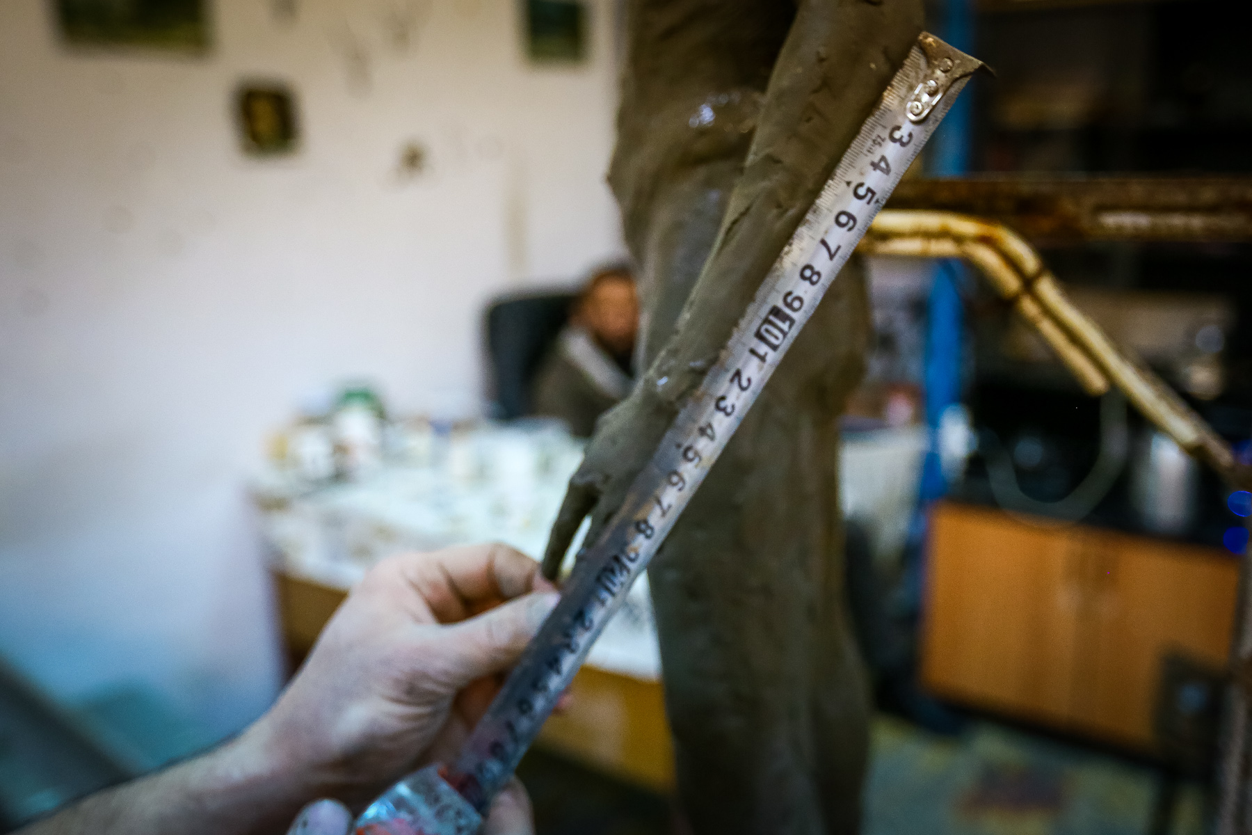 Naturadan qeyd etdiyi qolun ölçüsünü yeni hazırlayacağı heykəlin üzərinə tətbiq edir