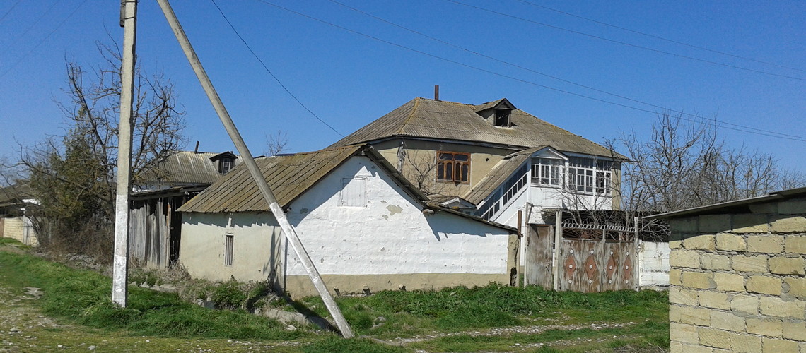 Старые дома вдоль неасфальтированной дороги села Палыдлы