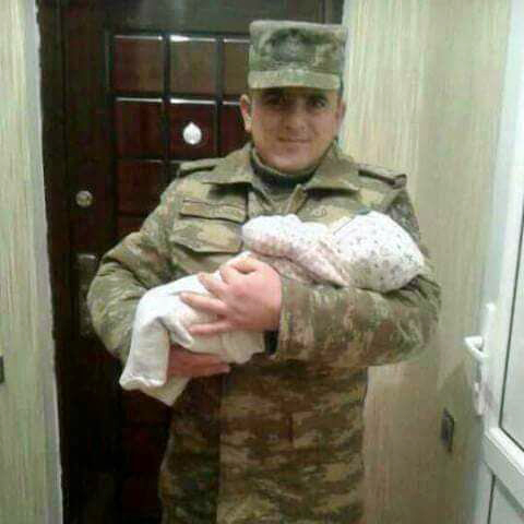 Suleyman Kazimov holding his infant son