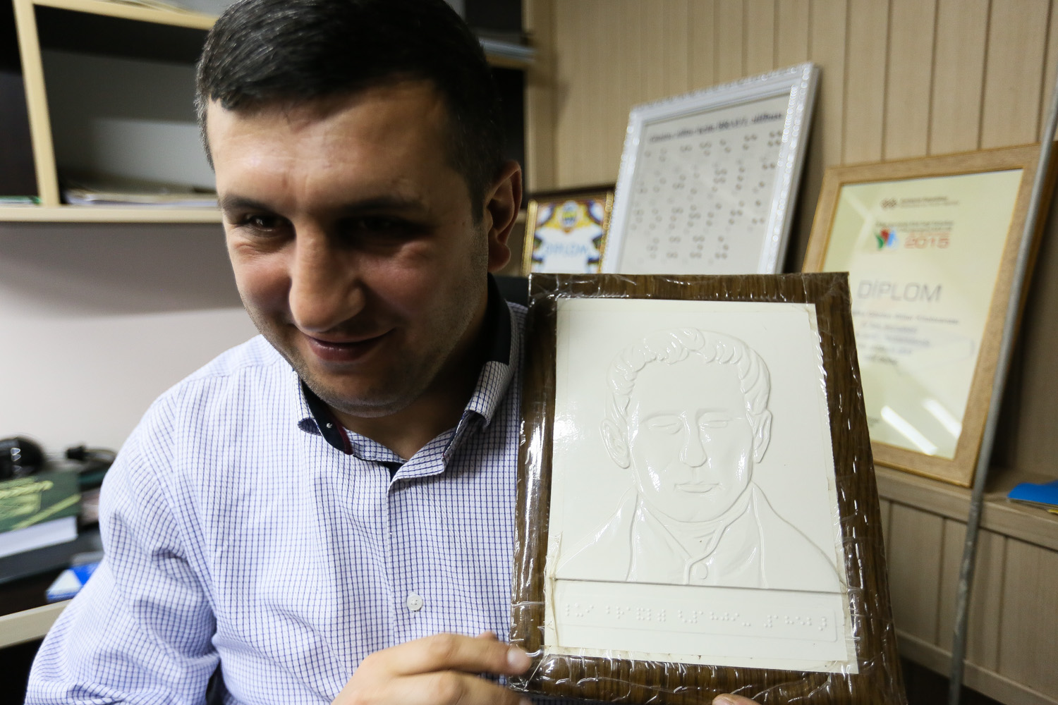 Tofiq Balayev Brayl əlifbasının yaradıcısı olan Luis Braylın portretini əlində saxlayıb.