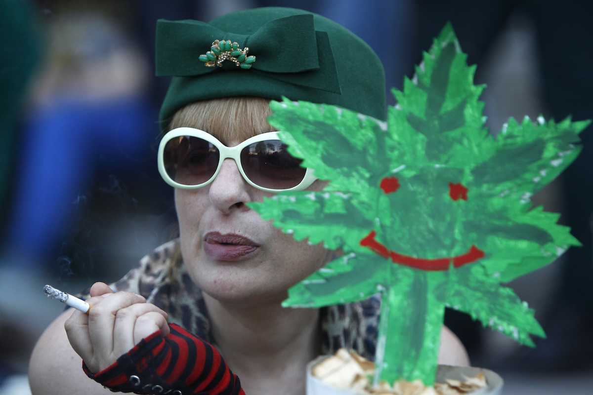 Женщина курит сигарету на акции, посвященной легализации марихуаны. Тбилиси, 2 июня, 2013 год. REUTERS/Давид Мдзинаришвили