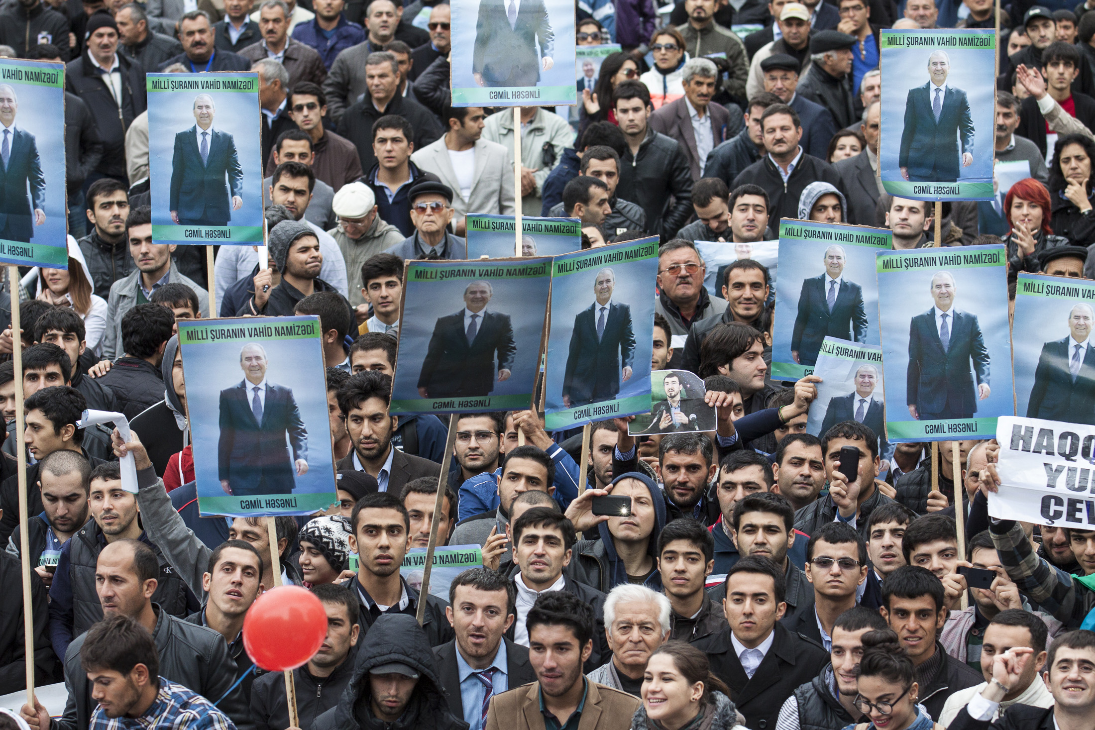 People hold election posters of Jamil Hasanly, a presidential candidate from the united opposition, during the final election rally in Baku October 5, 2013. REUETRS/Elmar Mustafazadeh