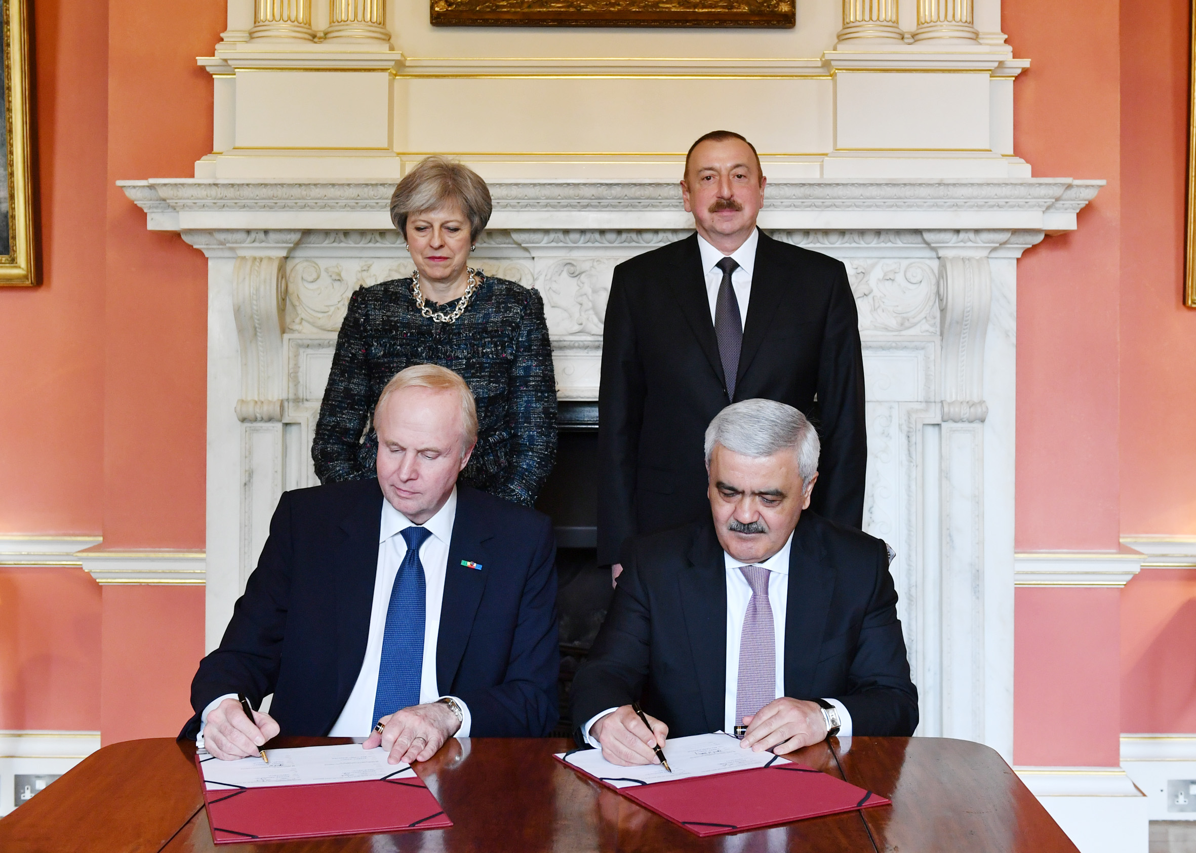 BP group chief executive Bob Dudley (seated, left) and SOCAR president Rovnag Abdullayev (seated, right) sign a new production sharing agreement as UK Prime Minister Theresa May and Azerbaijani President Ilham Aliyev look on.