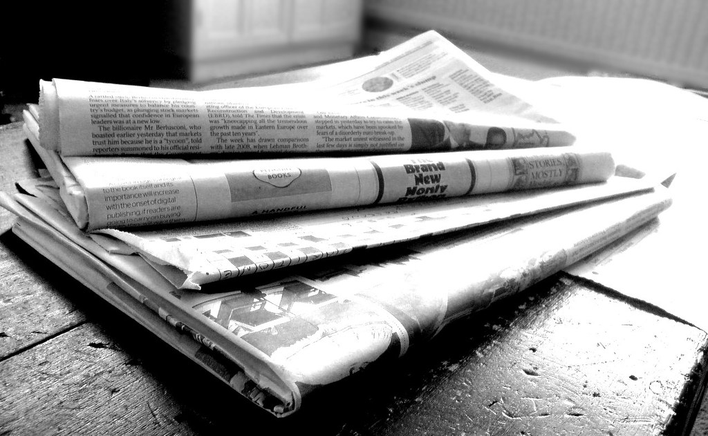 "Newspapers B&W (4)" by NS Newsflash is licensed under CC-BY 2.0. To view a copy of this license, visit https://creativecommons.org/licenses/by/2.0/.